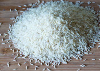 TORONTO, ONTARIO, CANADA - 2015/03/30: Small pile of long grain white rice over a wooden surface with natural illumination showing highlights and shadows, basmati rice in cutting board. (Photo by Roberto Machado Noa/LightRocket via Getty Images)